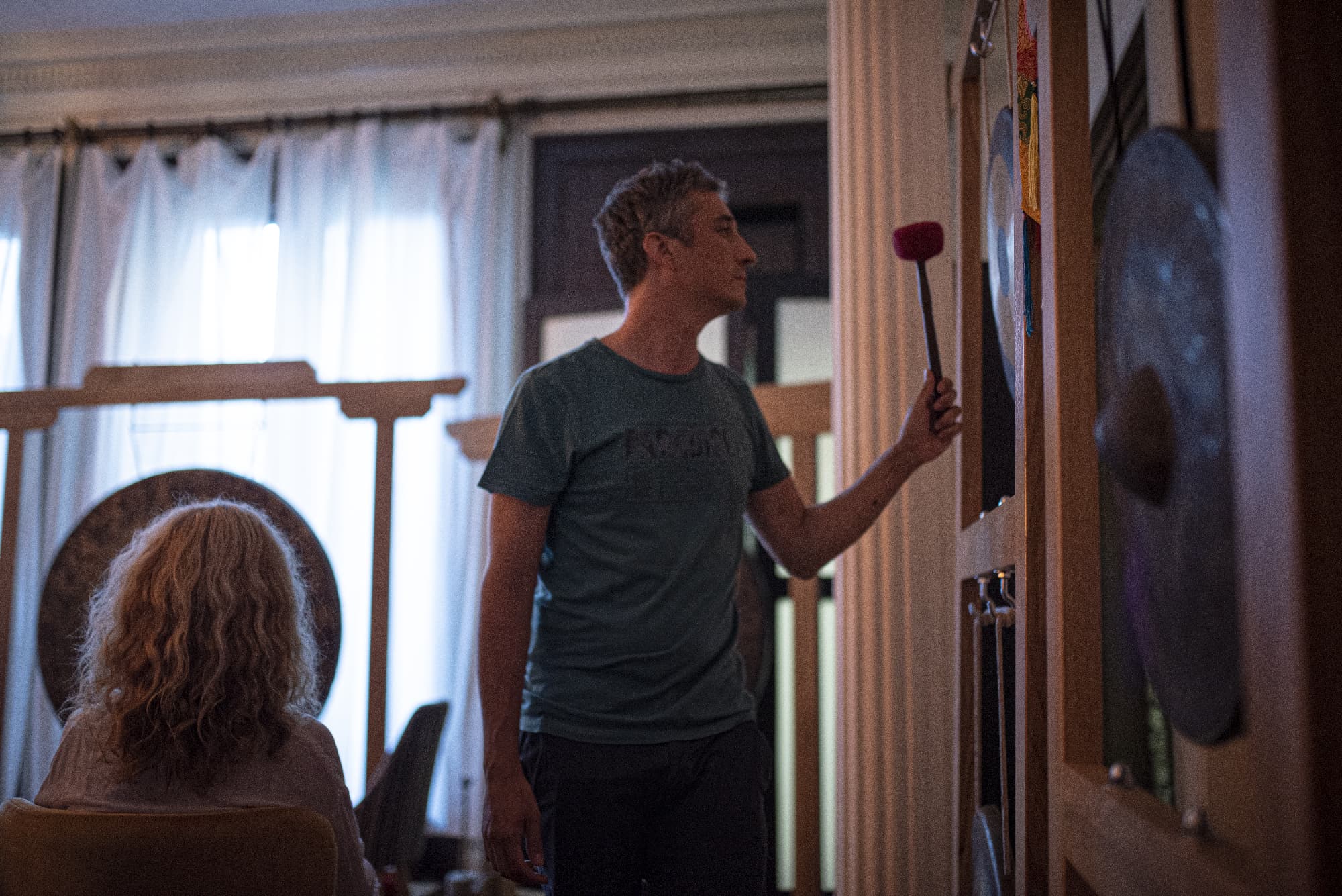 Atmospheric sound healing setting with warm light, instruments, and shared presence